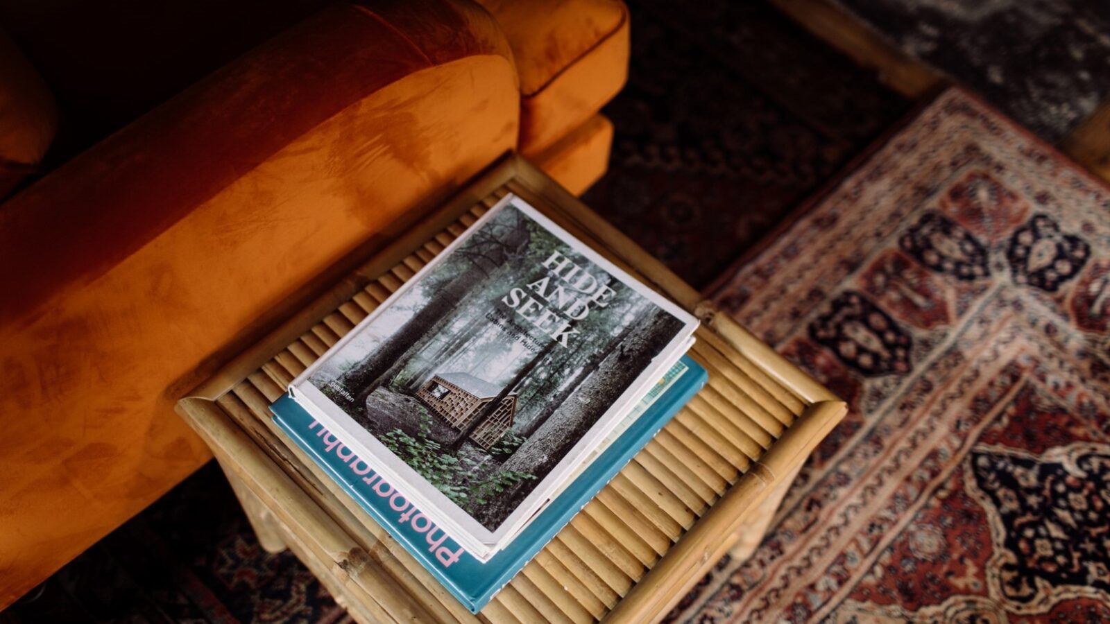 A small wooden table with a stack of books, featuring 